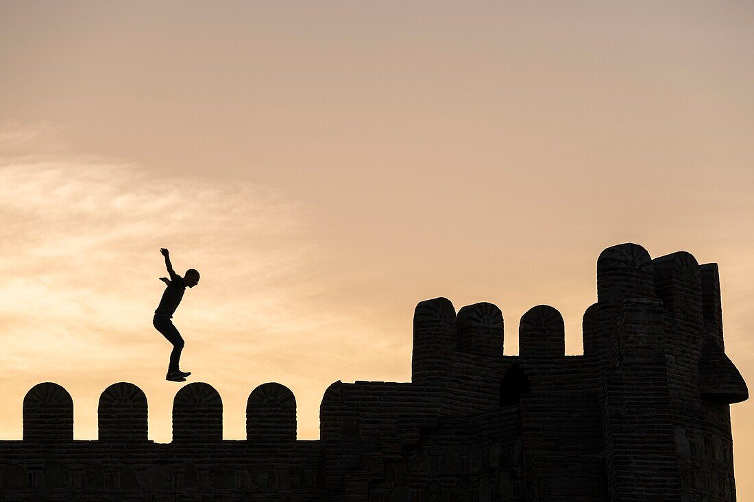 Georgia, Tbilisi, tourist doing acrobatics on Narikala fortress which overlooks the Old Tbilisi (or Dzveli Kalaki)