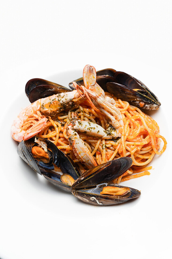 Delectable seafood pasta featuring succulent shrimp and fresh mussels, garnished with a fragrant parsley concoction on a plate.