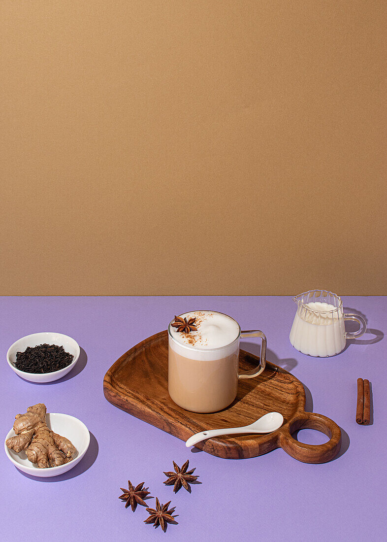 From above, Delicious chai latte with creamy foam, star anise placed on a vibrant background with fresh ingredients