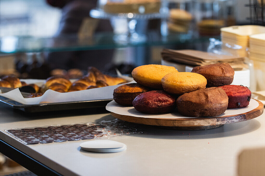 Assorted sweet vegan sponge cakes placed on wooden tray on counter in bakery