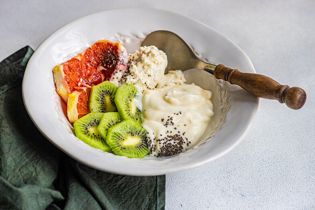 Start your day right with this healthful bowl of natural yogurt, cottage cheese, chia seeds, and freshly sliced kiwi and Sicilian orange