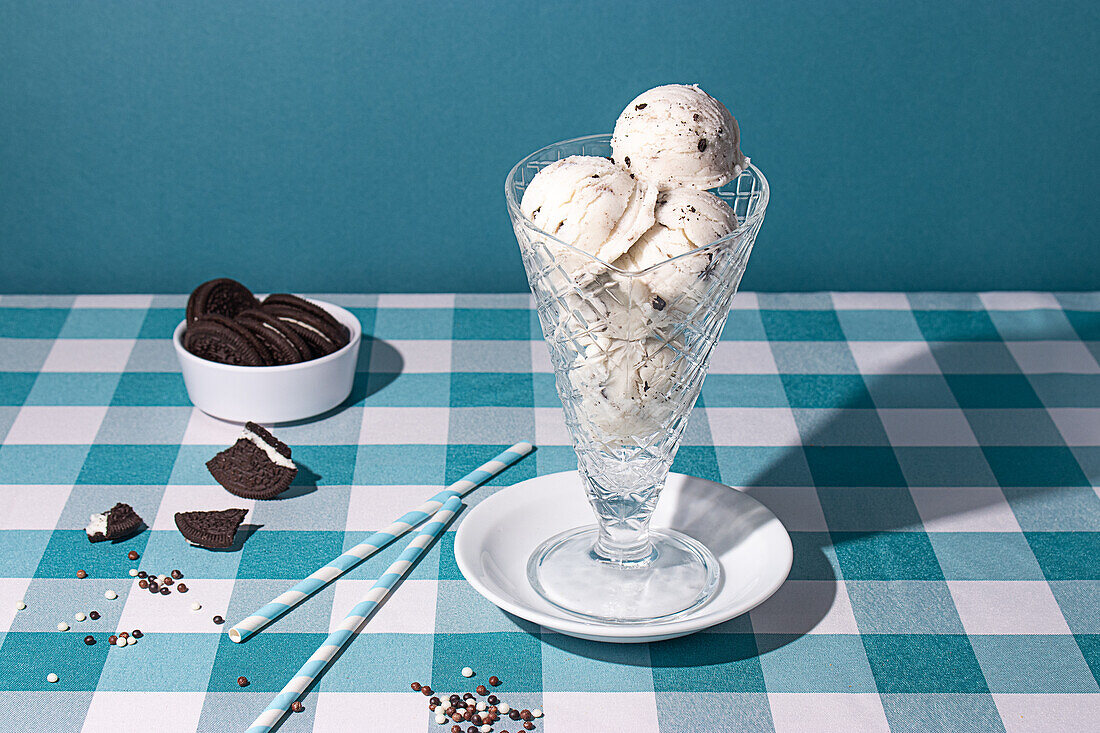 Creamy cookies and cream ice cream served in a crystal glass with chocolate biscuits on the side