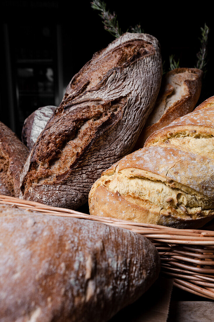 A selection of fresh, crusty sourdough breads, proudly handmade, arranged in a rustic wicker basket.