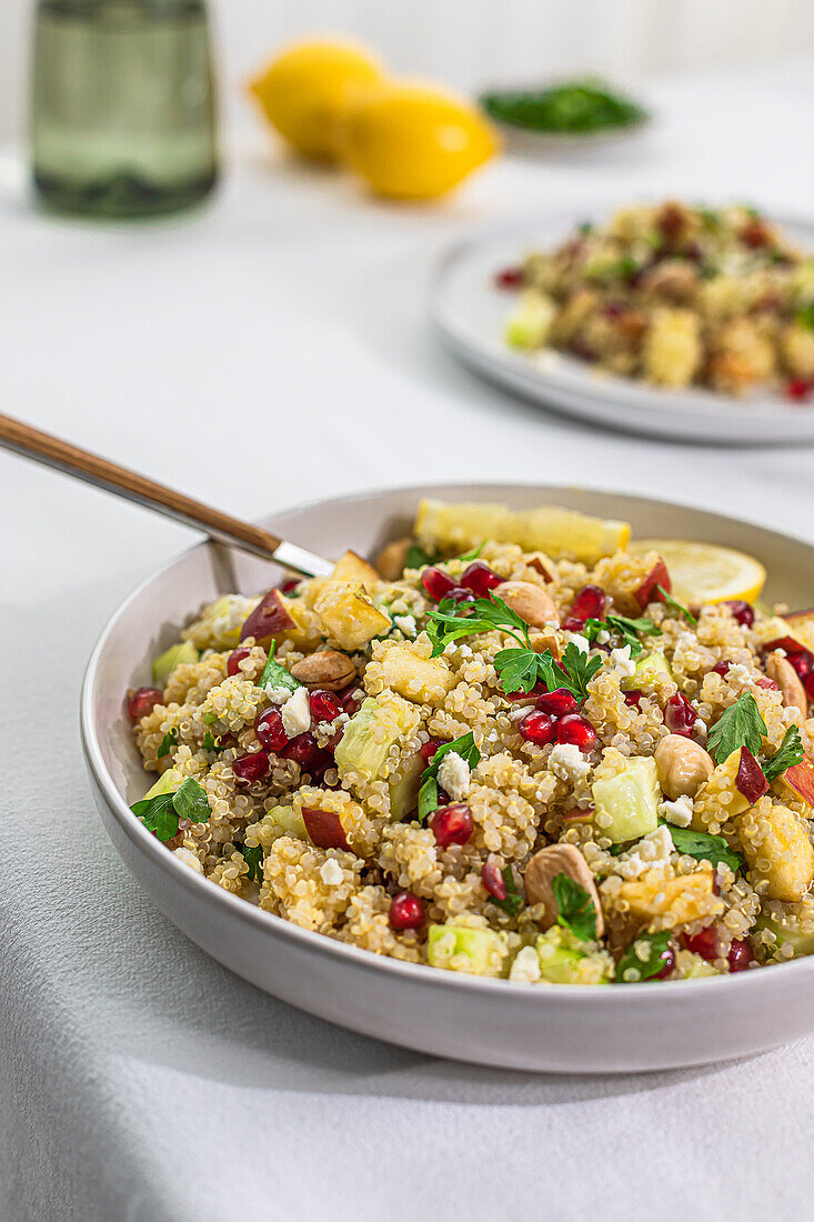 A vibrant bowl of curry-flavored quinoa salad with colorful ingredients, shot from an angled side view.