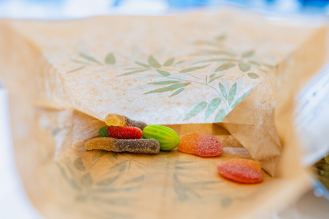 A variety of colorful, sugary candies carefully placed on a piece of patterned parchment paper, blurring the background