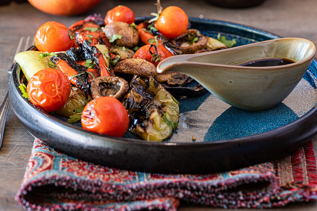 Ein lebendiger gegrillter Gemüsesalat mit gegrillten Kirschtomaten, Champignons, Paprika und Kopfsalat, serviert in einer stilvollen Keramikschale und mit einem Dressing