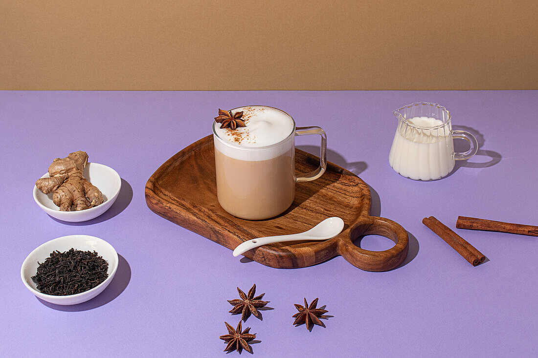 From above, Delicious chai latte with creamy foam, placed on a wooden board on a colorful backdrop