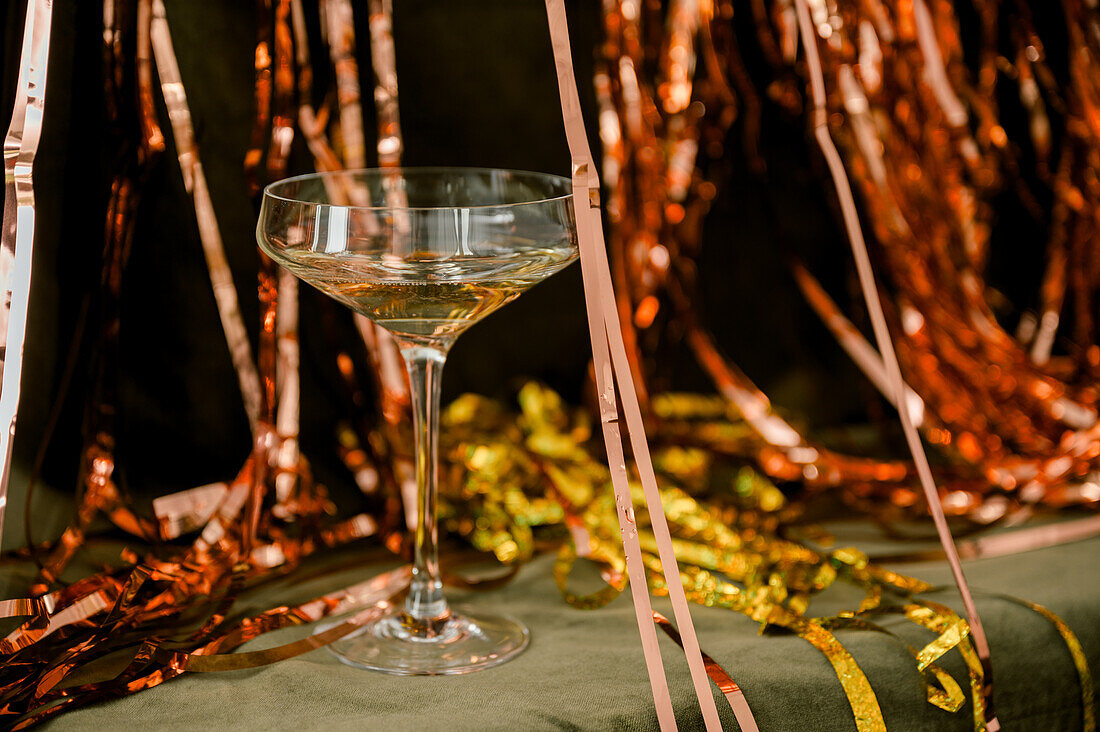 Champagne for new year greetings. Abstract golden background with champagne glasses and sparkler. Concept for celebrations with space for text.