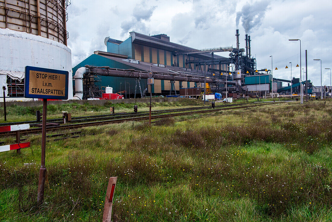 Riesiges, schweres Stahlwerk und Industriegelände, das verschiedene Stahlsorten in einer CO2-emittierenden und -ausstoßenden Fabrik herstellt. IJmuiden, Niederlande.