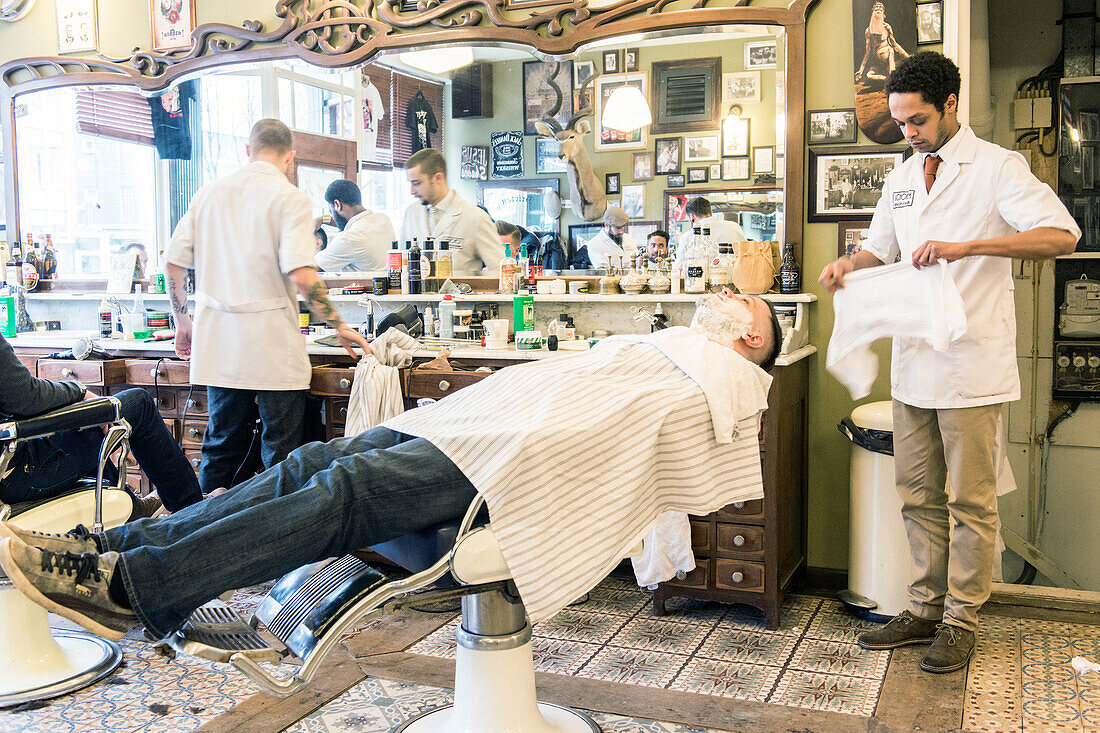 Professional Barber & Haircutter Shaving his Customer inside Schorem Barber Shop at Nieuwe Binnenweg, Rotterdam, Netherlands.