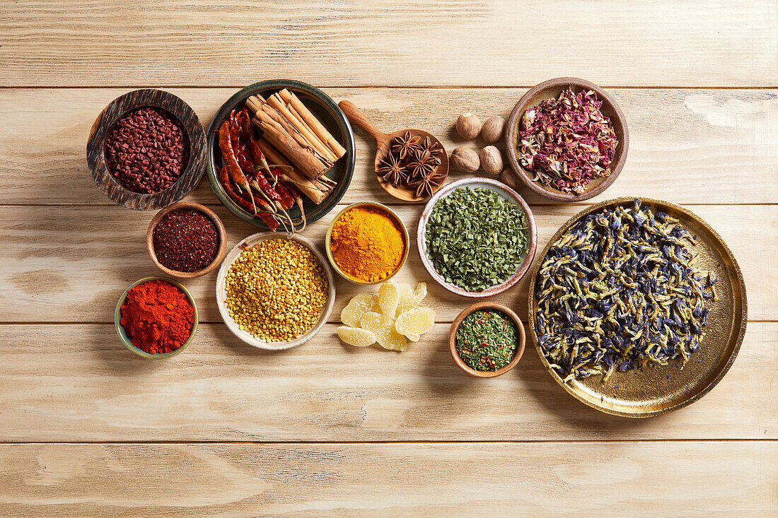 Group of herbs and spices on a light wood background