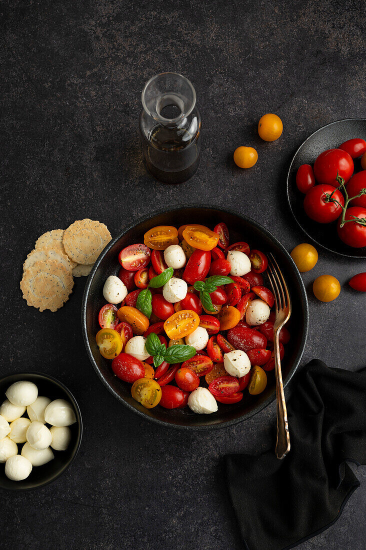 Frischer und lebendiger Caprese-Salat auf schwarzem Hintergrund