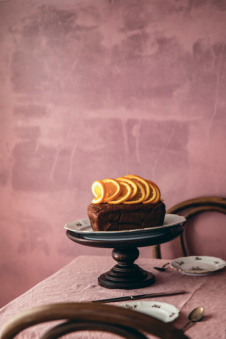 Orangenbrot auf einem Tisch mit rosa Hintergrund