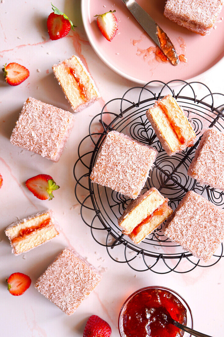 Australian pink Lamington Small square cake with strawberry jam and coconut coating.