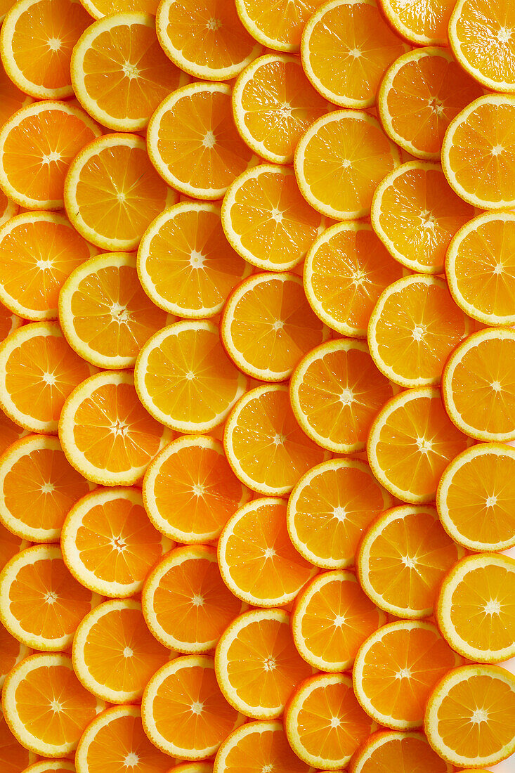 Lots of freshly cut orange slices laid out like peels from above