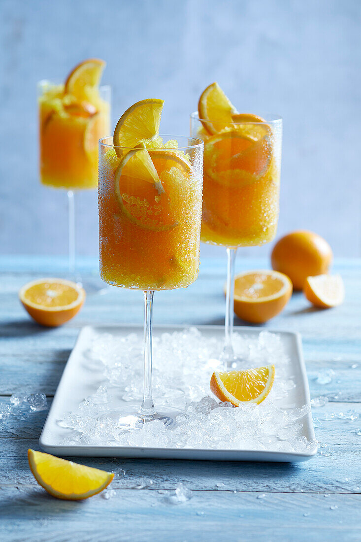 Ice cold orange slushy served in a tall stemmed glass