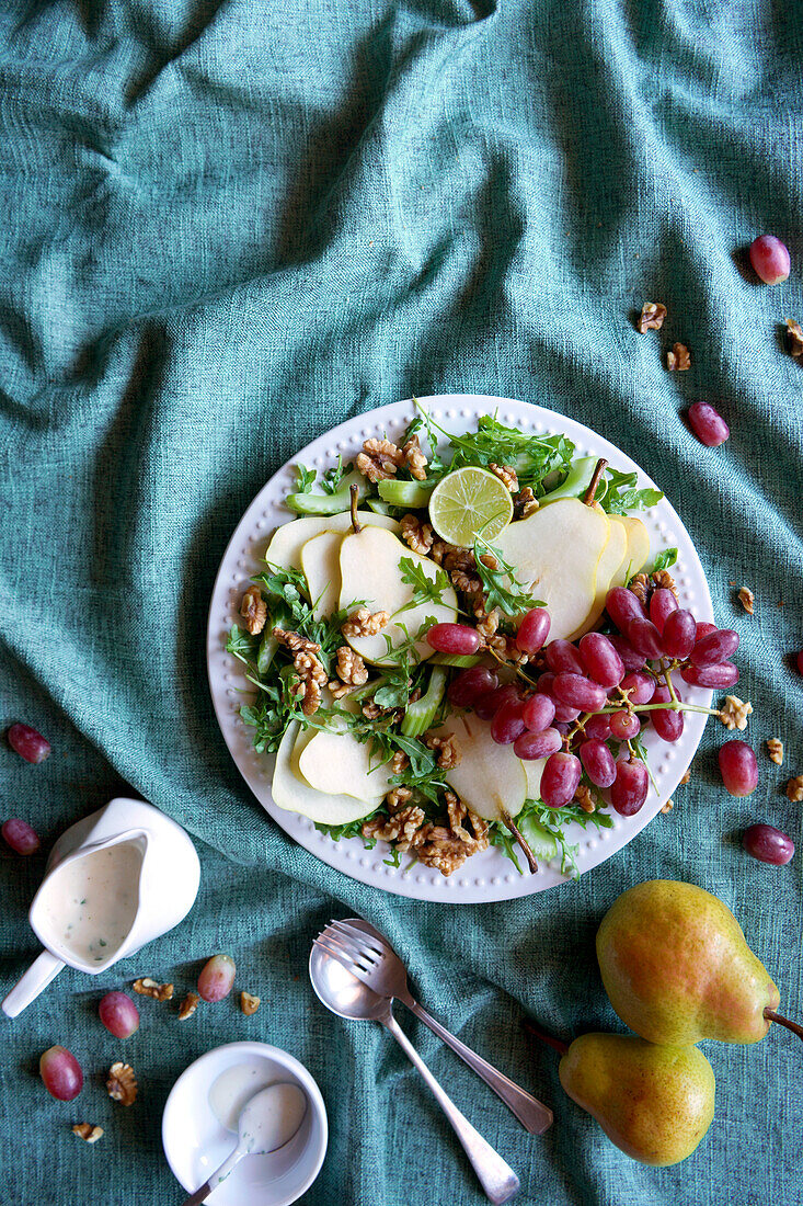 Waldorf-Salat mit Birnen, Walnüssen, Sellerie, Weintrauben und Baby-Rucola-Blättern. Negativer Kopierraum.