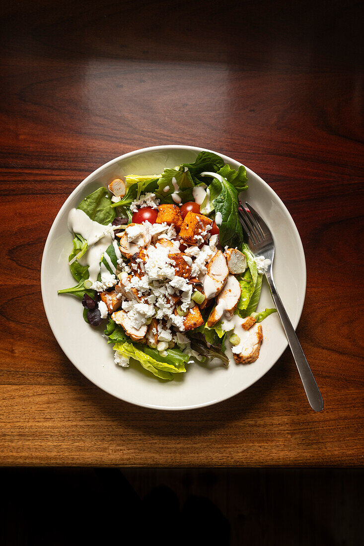 Hühnersalat in einer Schüssel auf einem Holztisch.