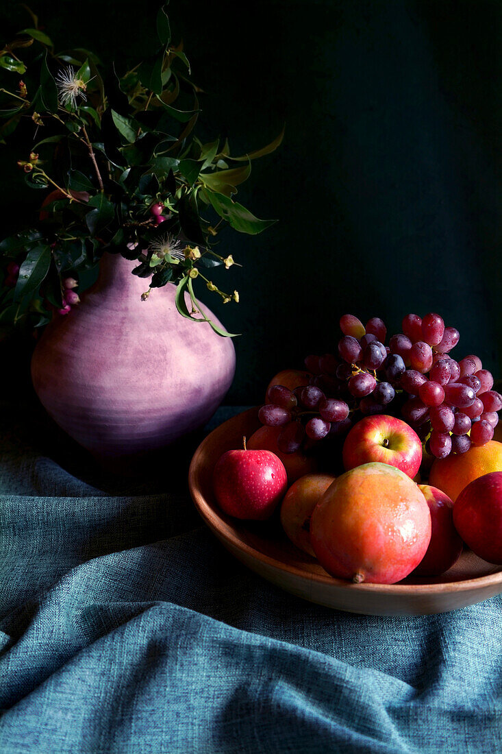 Saisonale Herbstfruchtschale mit Äpfeln, Mangos und Trauben.