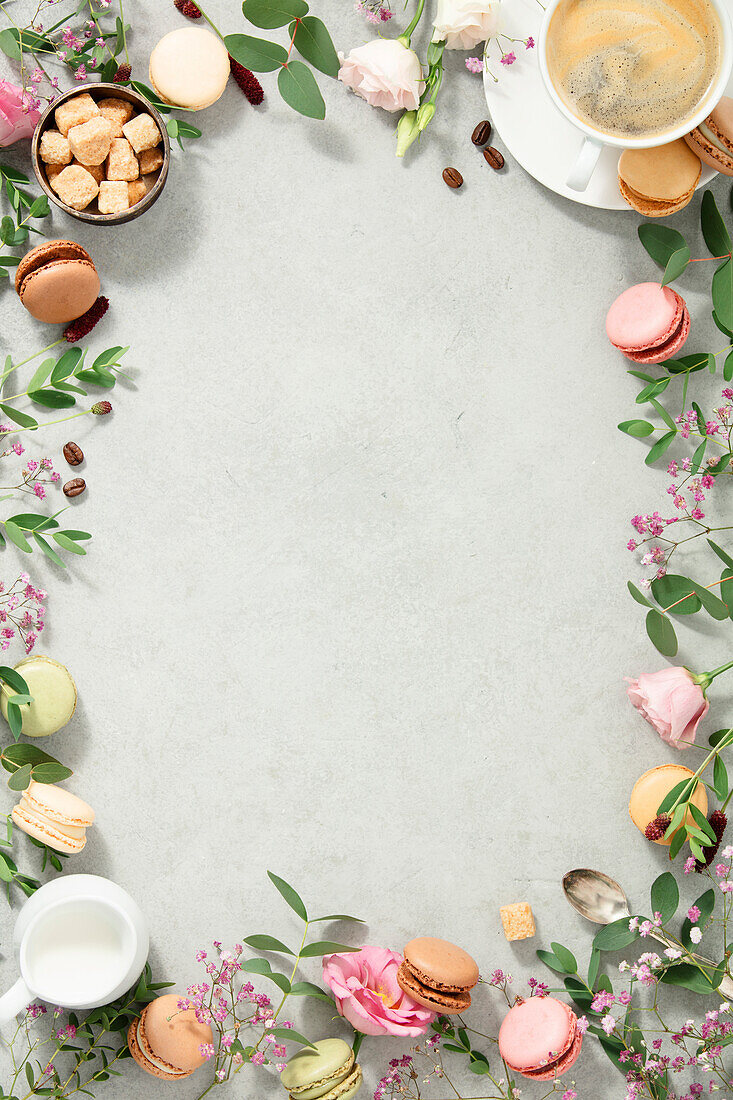 Frame made of Spring flowers,Different types of macaroons and coffee flat lay