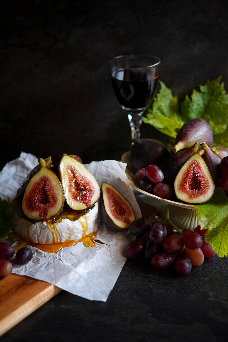 Brie cheese served with figs, honey and grapes.