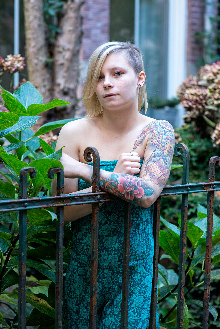 Portrait Young Woman with Tatoos in Residential Garden. Tilburg, Netherlands.