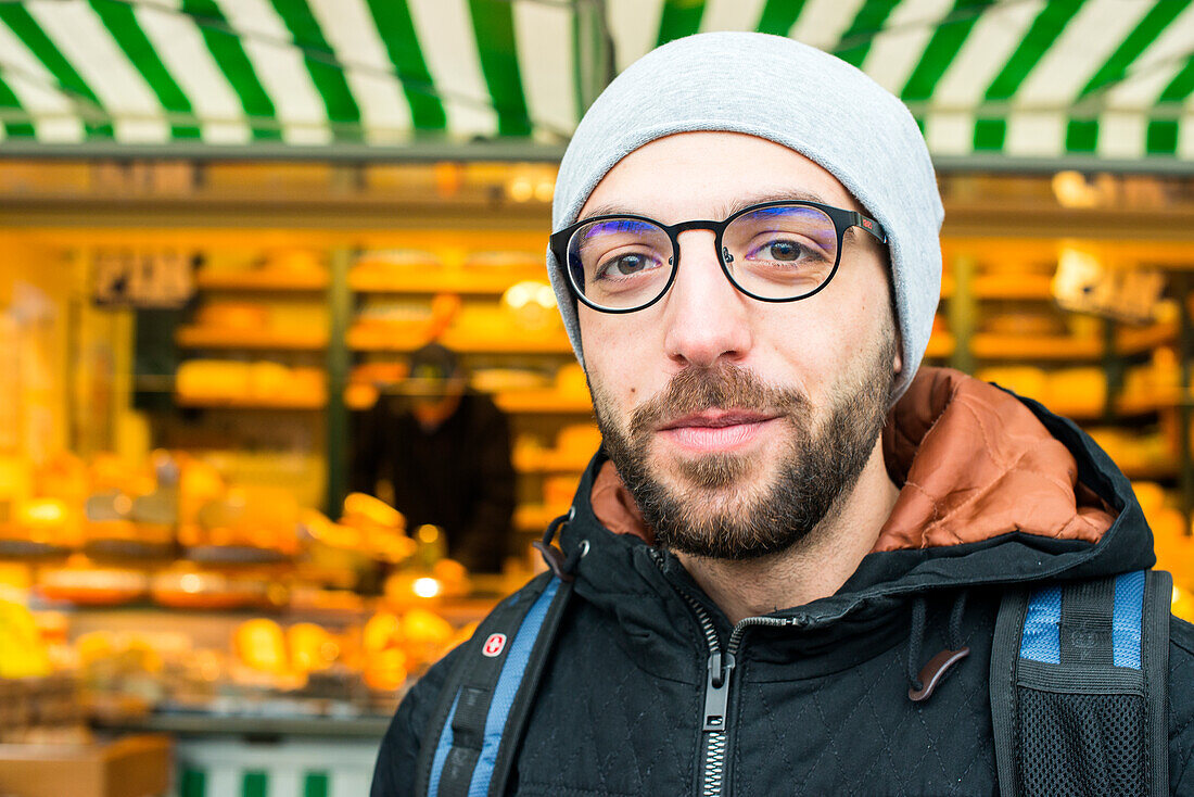 Tilburg, Netherlands. Former Syrian refugee visiting a Dutch market cheese stall at the weekly saturday market as part of his integration process.