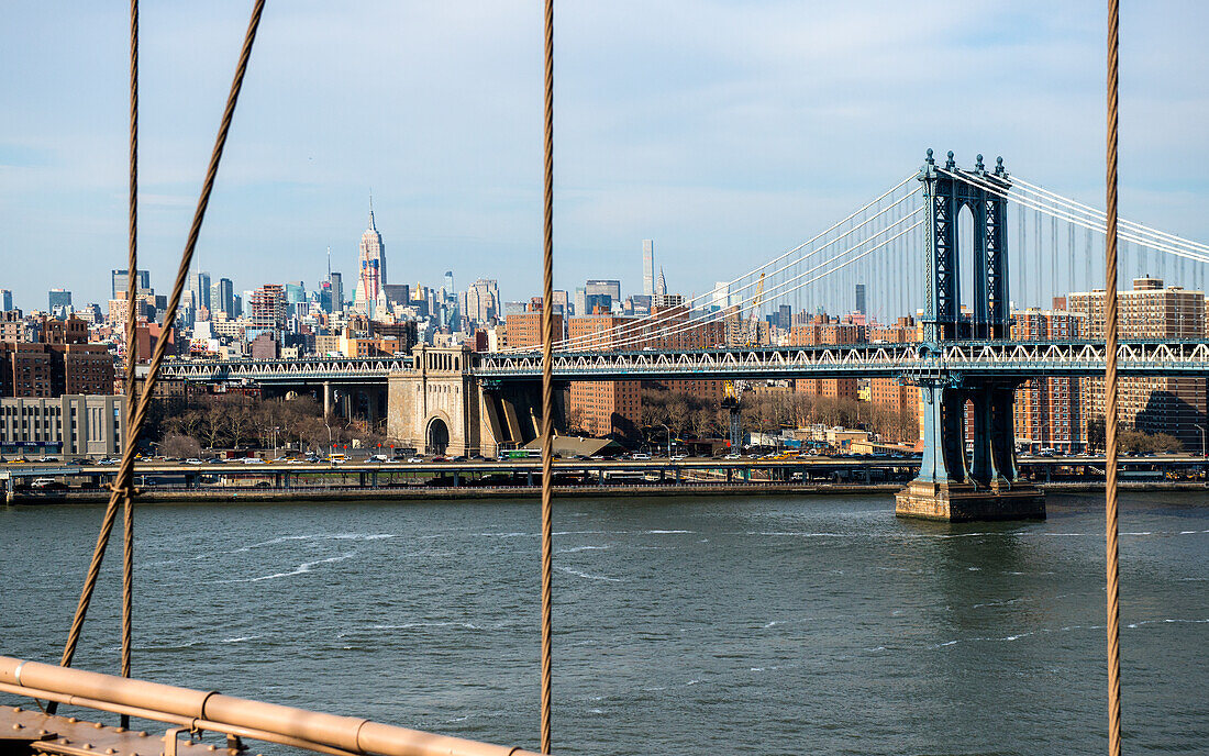 New York City, USA. Die Manhattan Bridge und die Skyline von Manhattan vom Brooklyn Bridge Walkway aus.