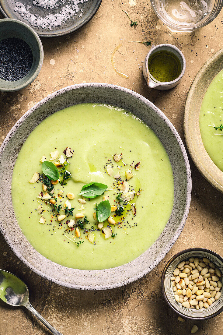 Green soup bowl with herbs on a brown background