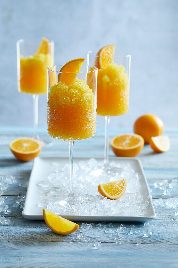 Eiskalter Orangen-Slushy, serviert in einem hohen Stielglas