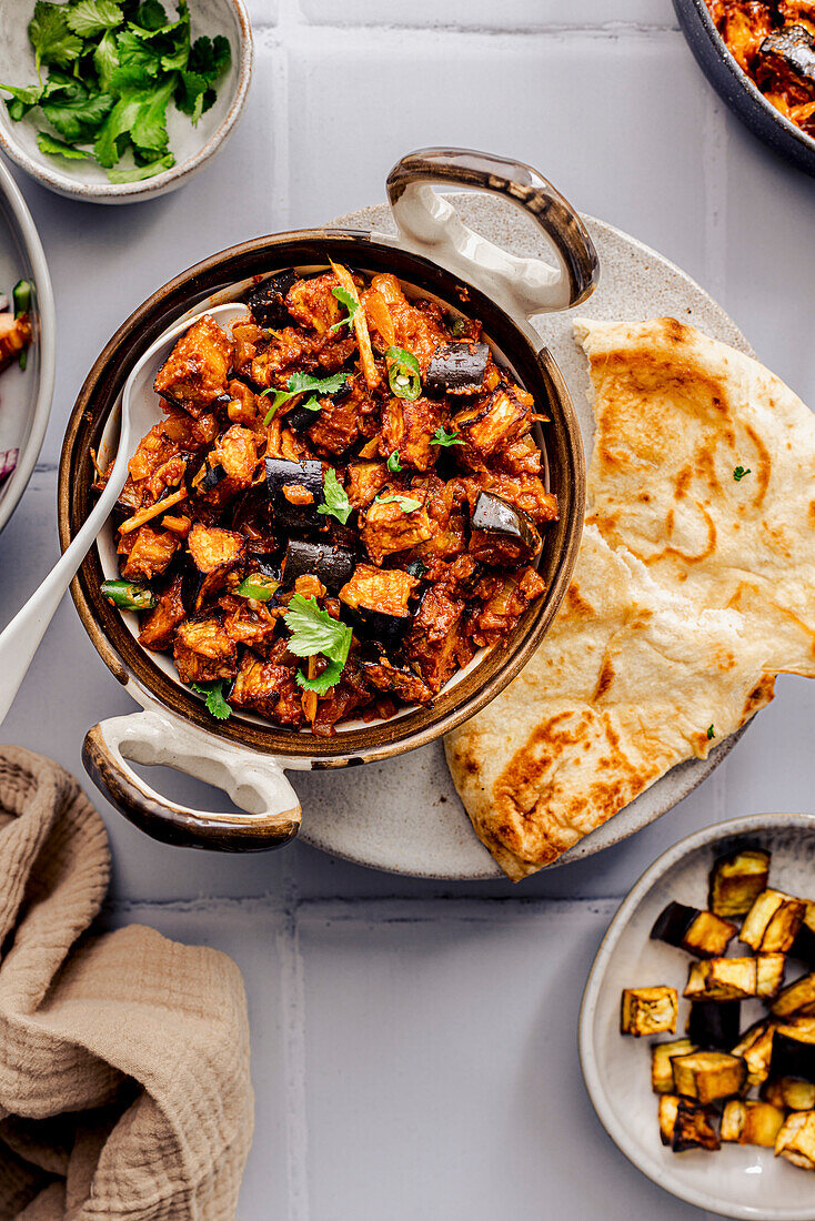 An aubergine bhaji, traditional Indian cuisine served with accompaniments