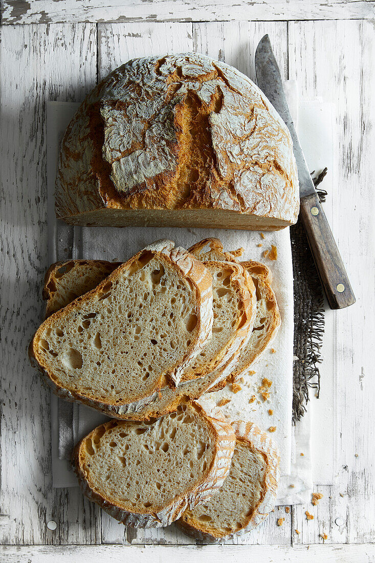 Frisch gebackenes Weizenbrot auf weißem Holzuntergrund