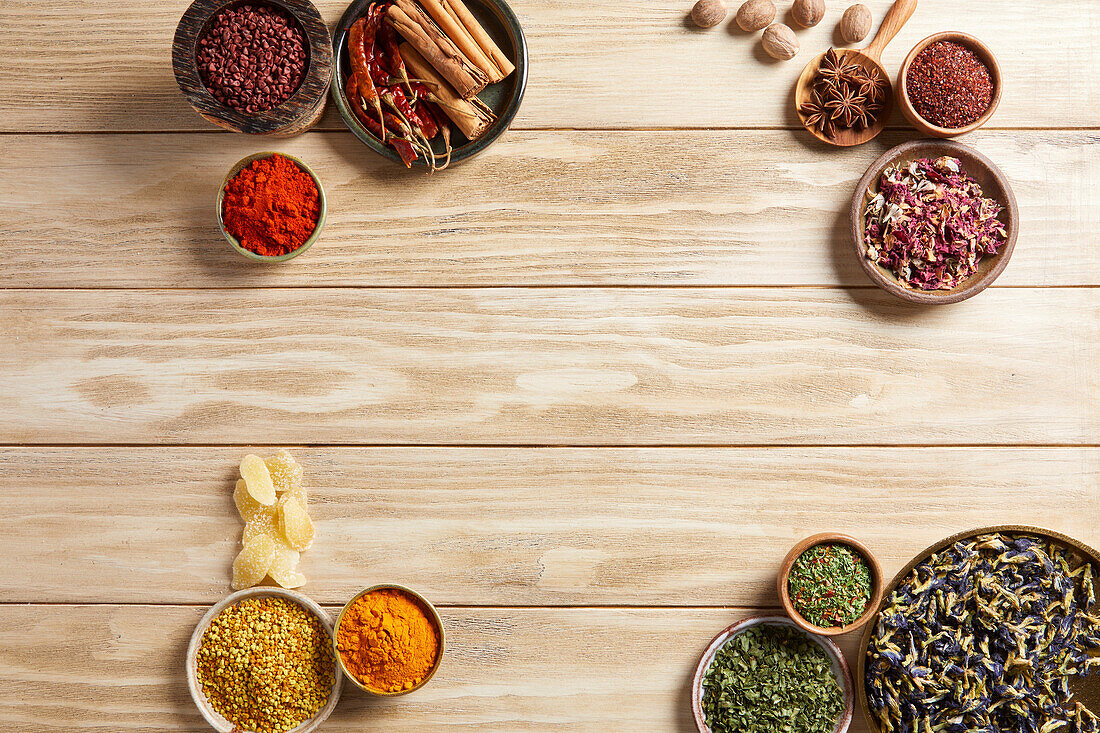 A group of herbs and spices on a light wood background