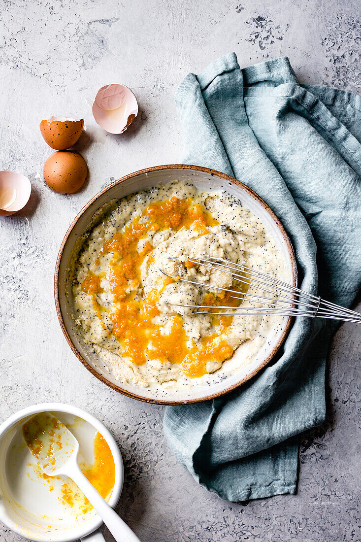 Citrus almond flour poppy seed pancakes in preparation. Hands whisking.