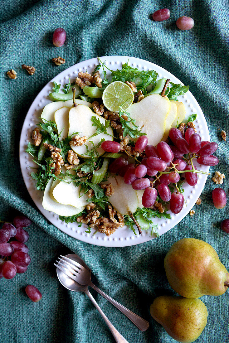 Waldorf salad with pears, walnuts, celery, grapes and baby rocket leaves. Close-up.