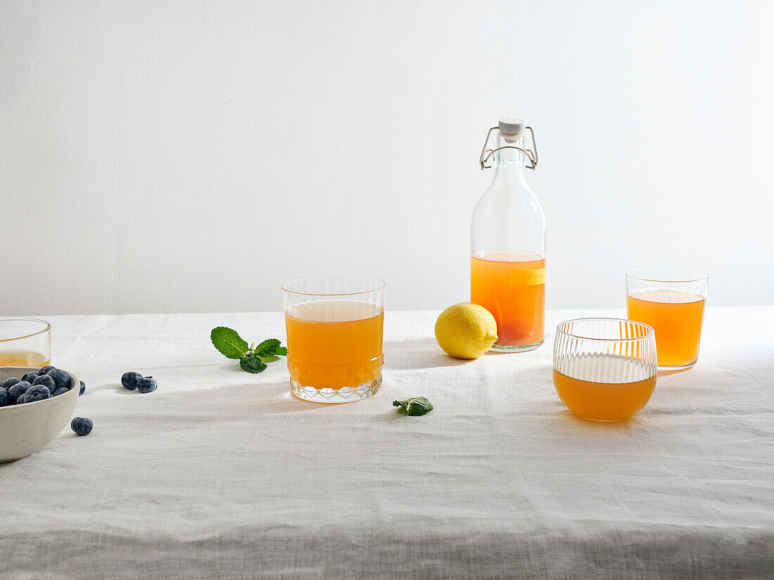 Homemade fermented kombucha drink with fruit flavour on white background