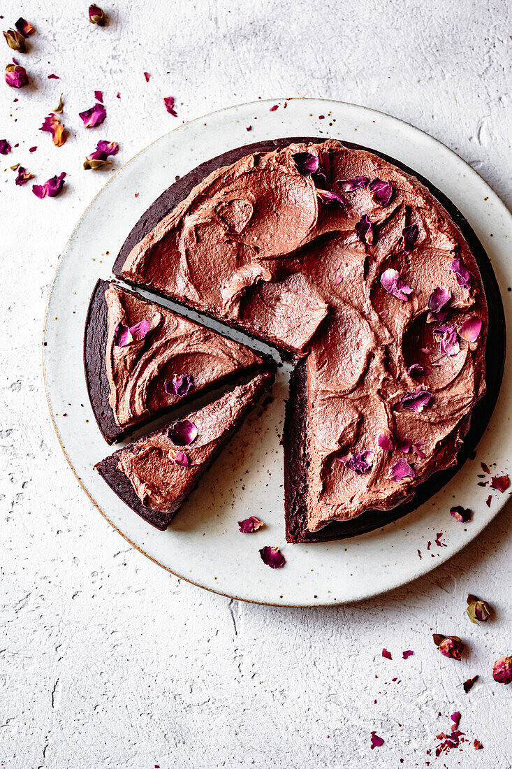 Chocolate cake with chocolate icing and dried rose petals