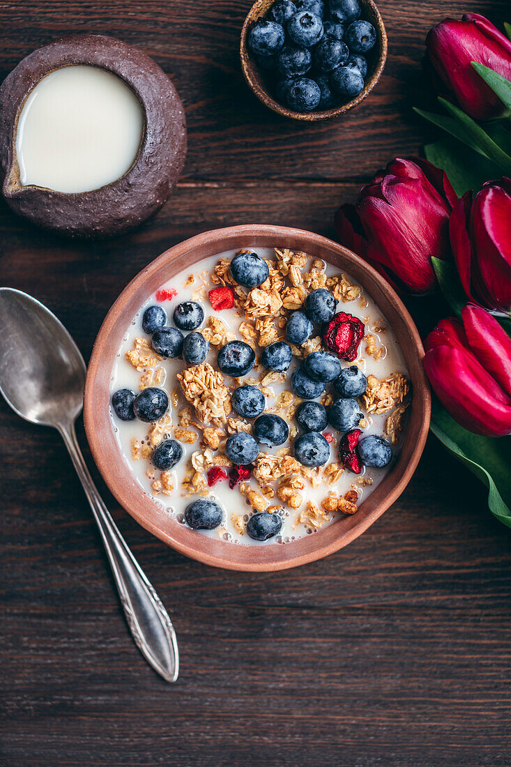 Granola with cherries and blueberries in a ceramic bowl