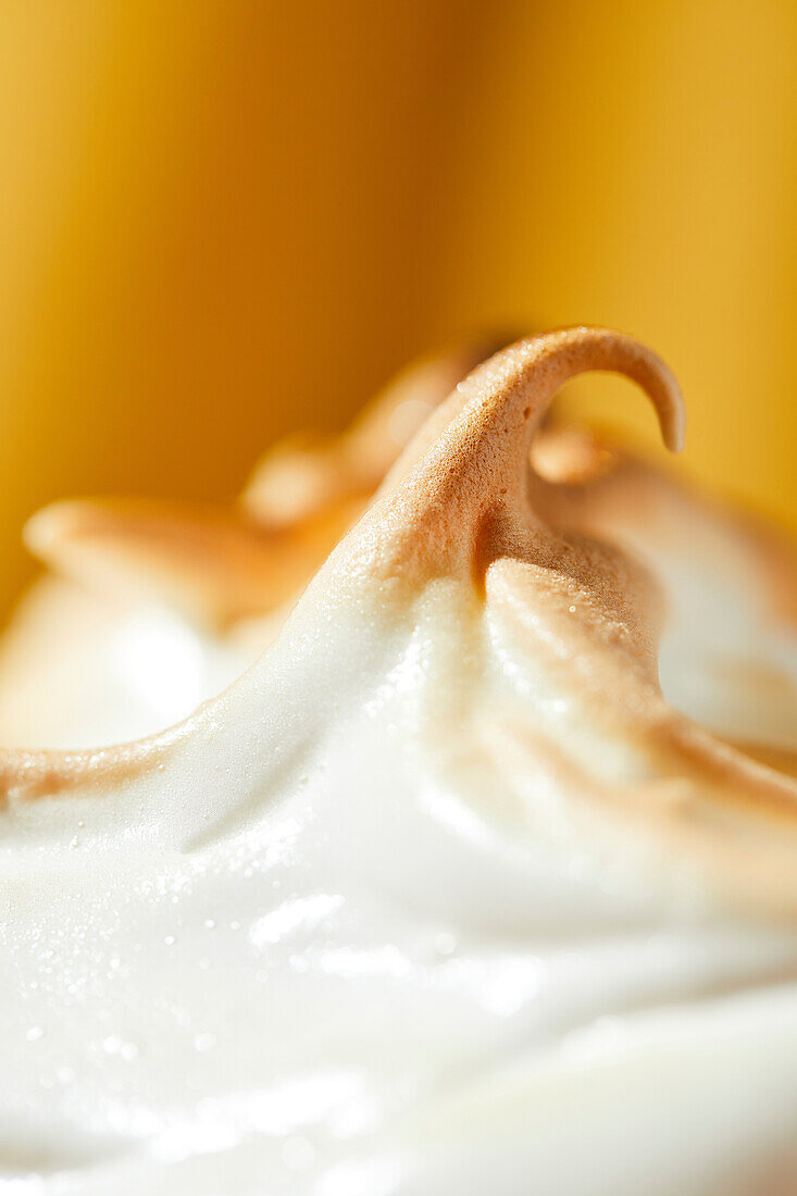 Meringue close-up and detail shot on a yellow background