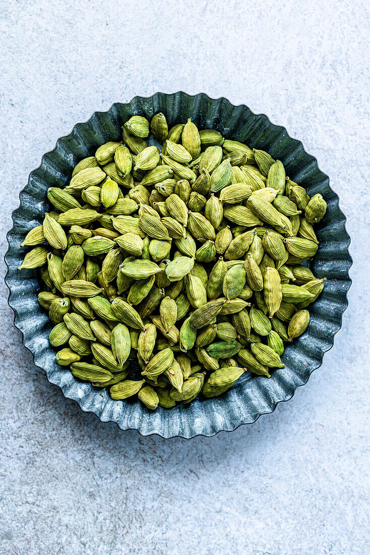 An ingredient made from cardamom seeds in a blue bowl