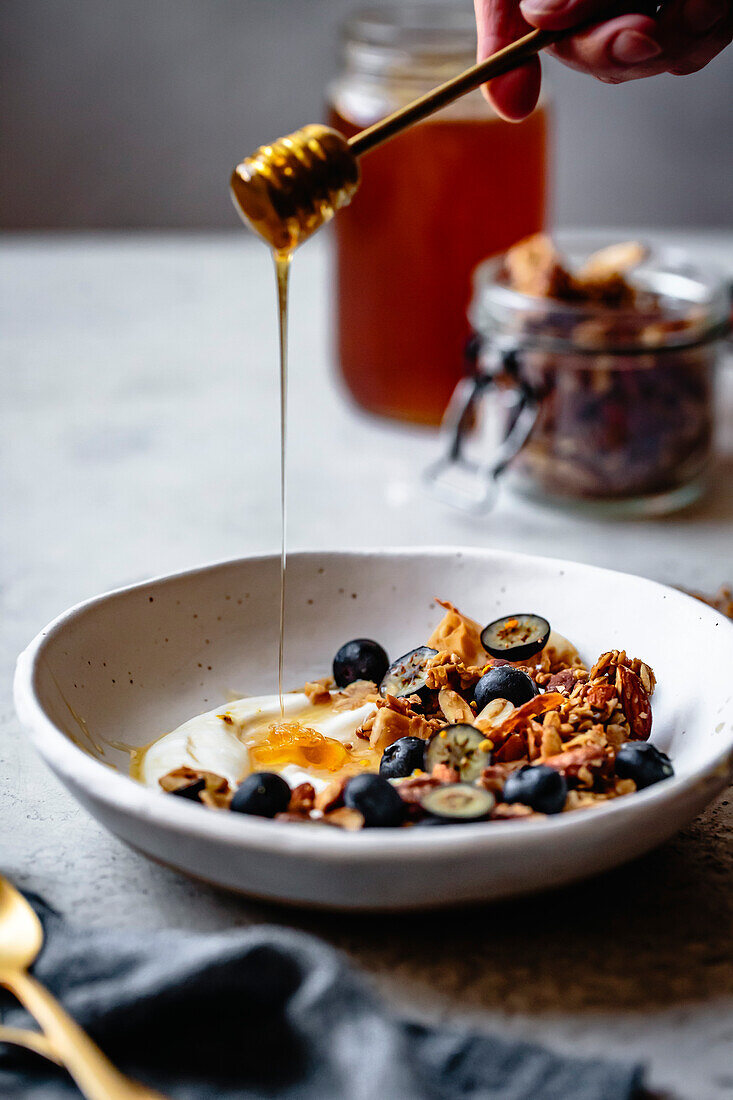 Joghurt-Granola-Schale mit Honig und Blaubeeren