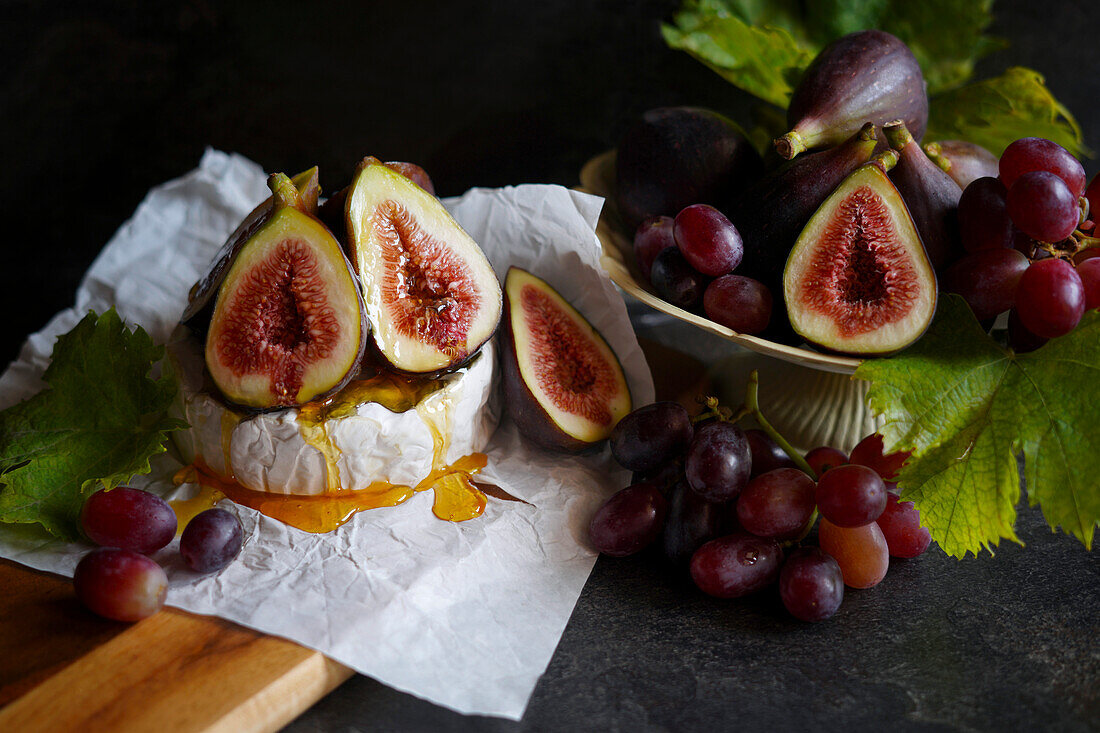 Brie cheese served with figs, honey and grapes.