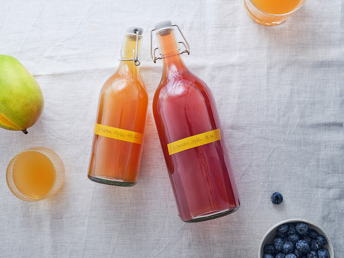 Draufsicht auf zwei Flaschen mit verschiedenen Geschmacksrichtungen des hausgemachten fermentierten Getränks Kombucha