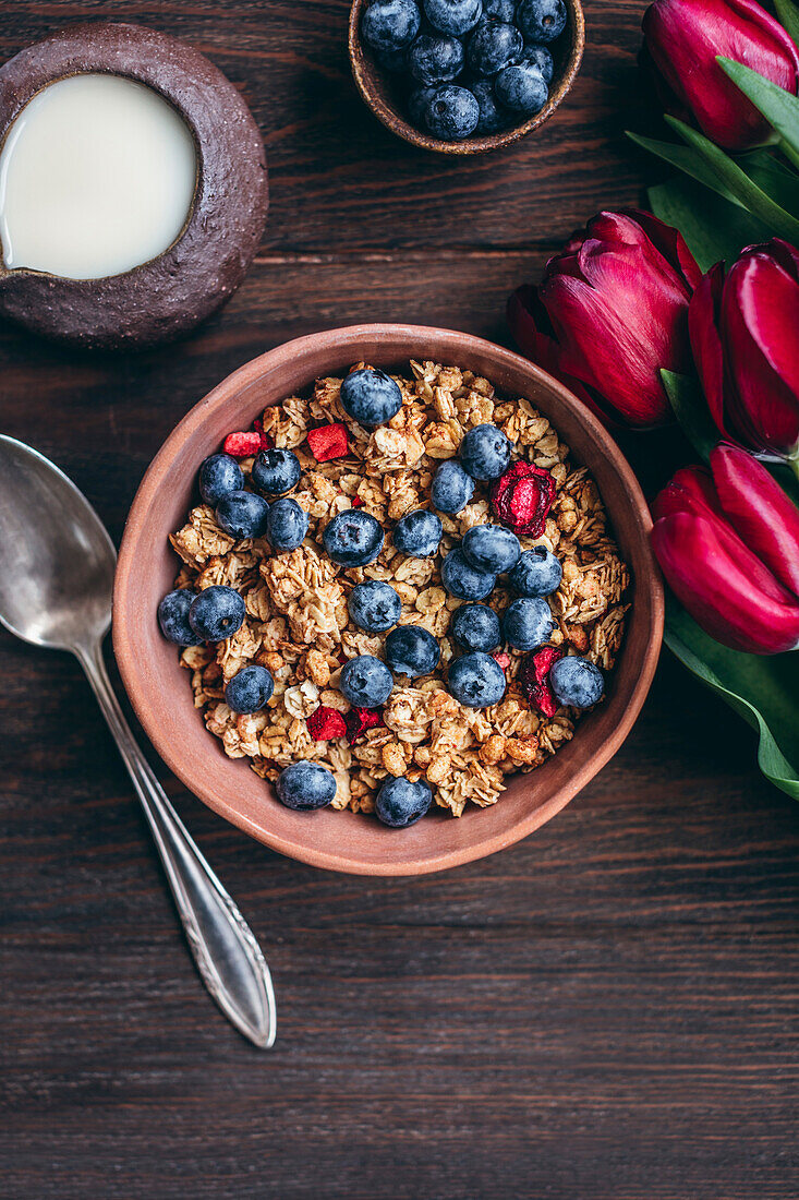 Granola with cherries and blueberries in a ceramic bowl