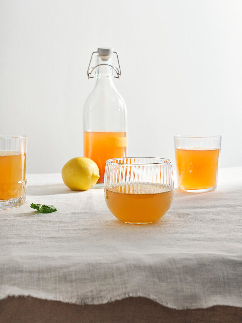 Homemade fermented kombucha drink with fruit flavour on white background