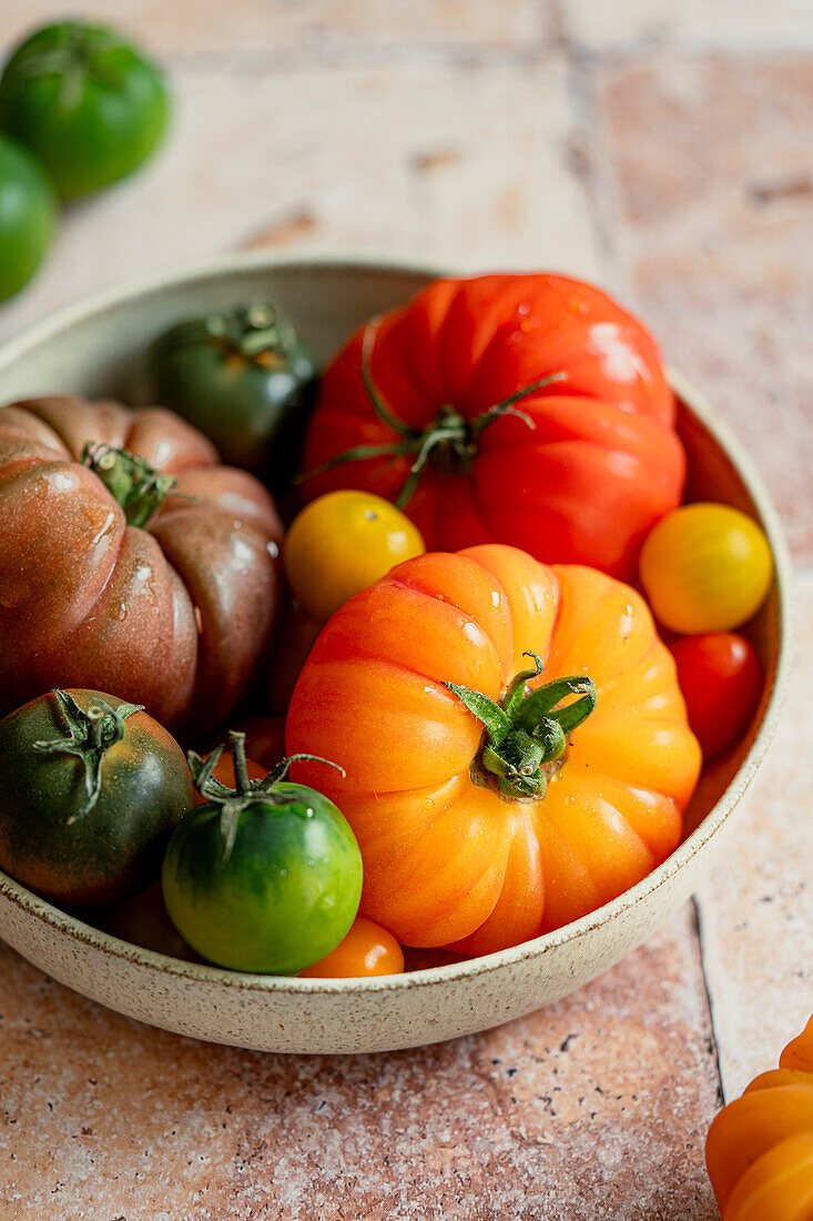 Frische, bunte Tomaten auf getöntem Hintergrund