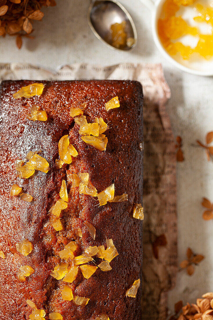 A loaf cake topped with chopped pieces of stem ginger