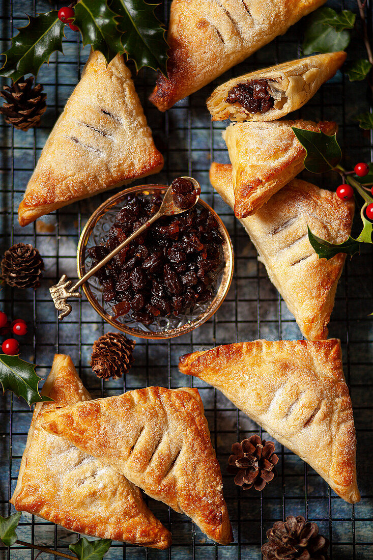 Mincemeat turnovers (Godcakes) on a wire rack with a saucer of sweet mincemeat alongside them.