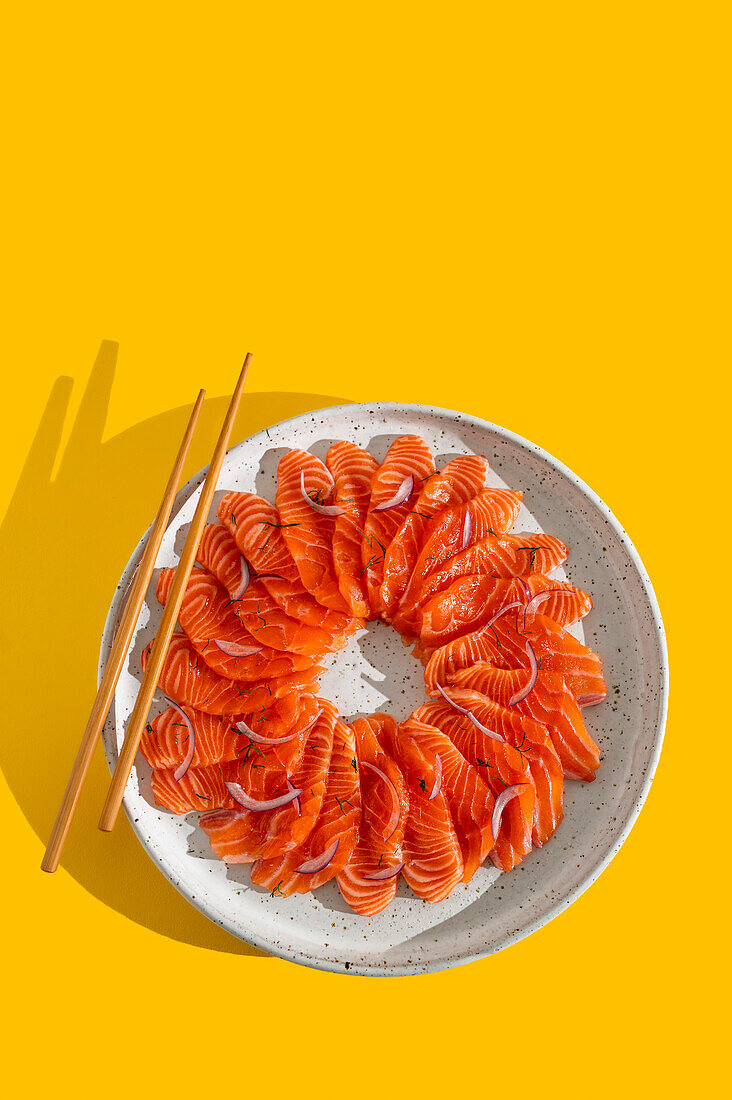 Fresh Plate of Salmon Crudo on Yellow Backdrop