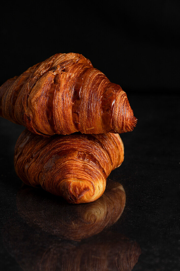 Zwei frische Croissants auf schwarzem Hintergrund